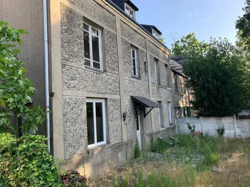 Avant — façade de bâtisse ravalée, enduit et modénatures restaurées