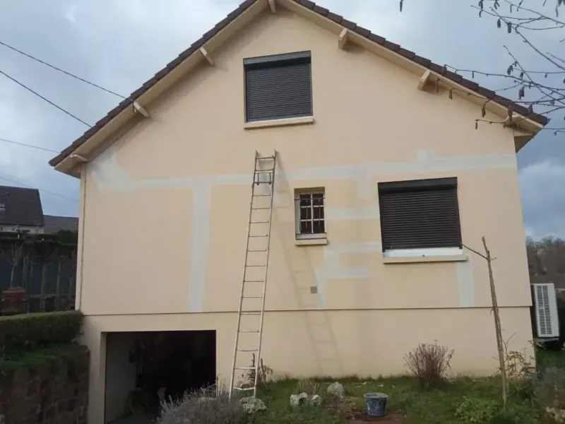 Façade enduite en cours de rénovation, avec zones de réparation visibles avant finition