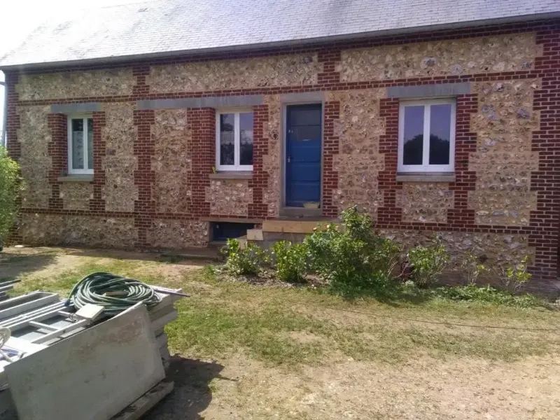 Façade en silex et brique avec porte d'entrée bleue